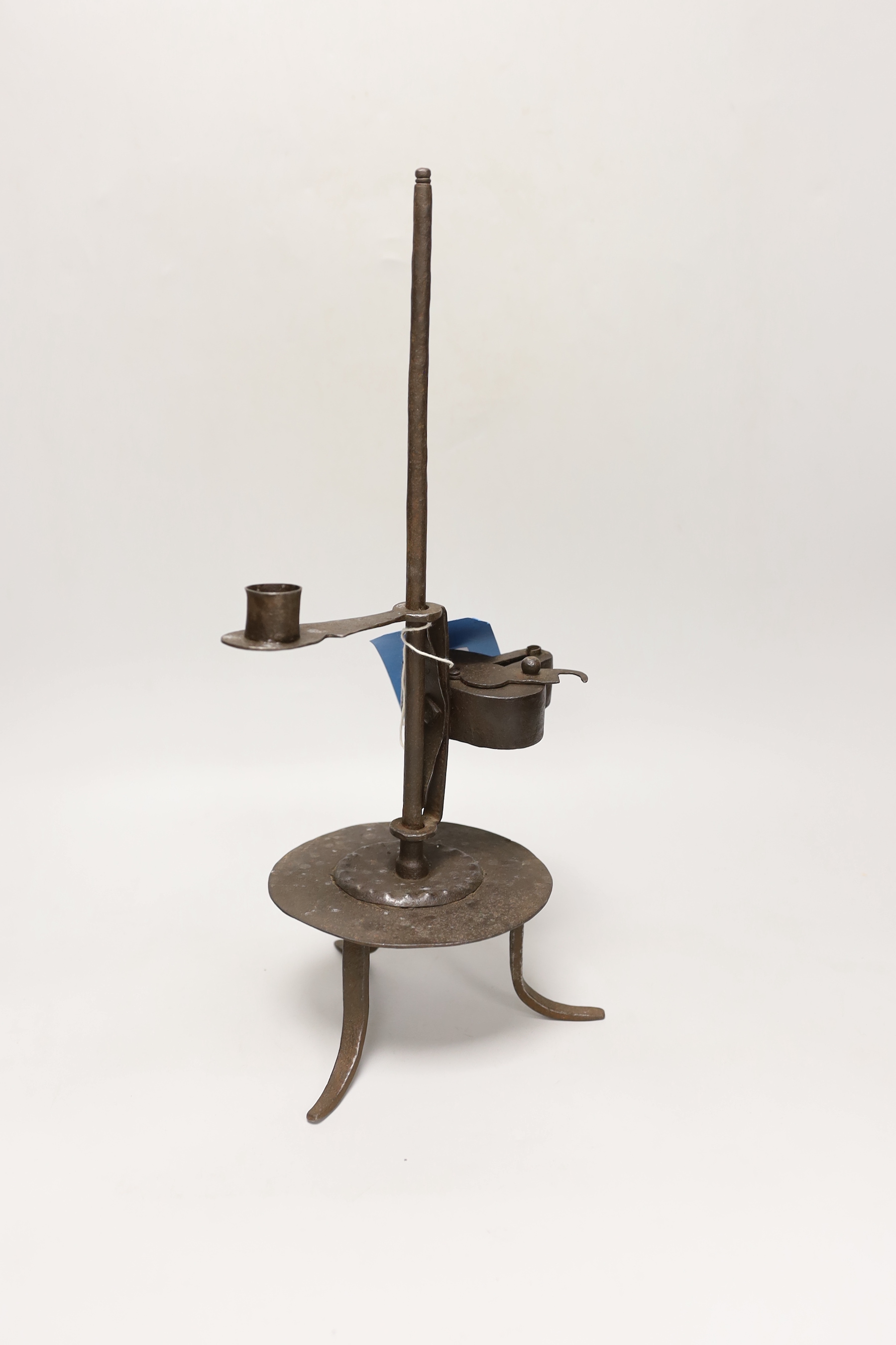 An 18th century Continental iron adjustable candle holder incorporating a crusie lamp, 41cm